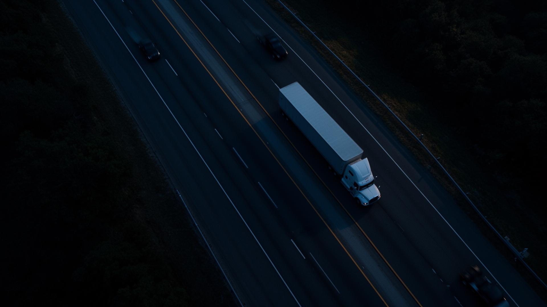 Aerial view of a semi-truck on the highway at dusk